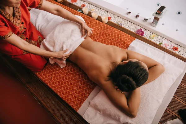 Top view of masseur taking off towel from woman in spa salon — Stock Photo