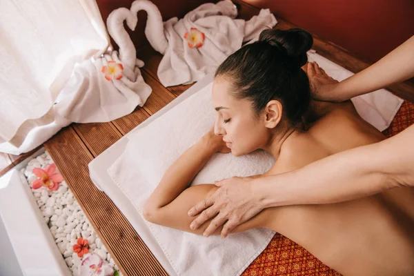 Recortado vista de masajista haciendo hombro masaje a mujer en masaje mat - foto de stock
