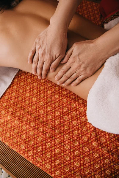 Cropped view of masseur doing back massage to woman on massage mat — Stock Photo