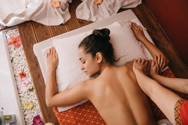 Vista ritagliata del massaggiatore facendo massaggio della mano alla donna nel salone spa — Foto stock