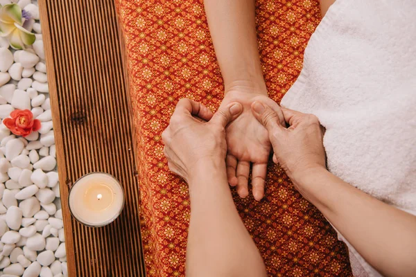 Vista cortada de massagista fazendo massagem de mão para a mulher no salão de spa — Fotografia de Stock