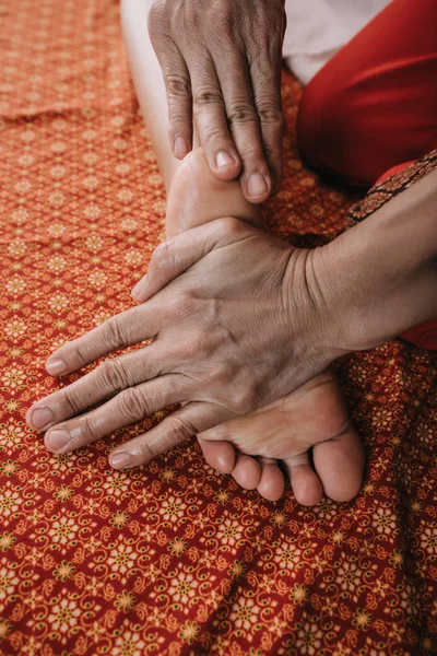 Vista recortada de masajista haciendo masaje de pies a mujer en salón de spa - foto de stock