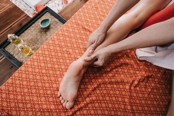 Vista cortada de massagista fazendo massagem nos pés para a mulher no salão de spa — Fotografia de Stock
