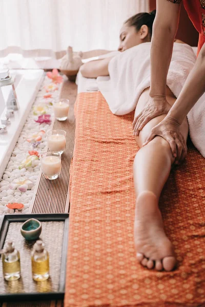 Vue recadrée du masseur faisant massage des pieds à la femme dans le salon de spa — Photo de stock