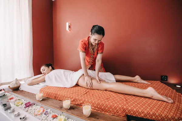 Asiático masajista haciendo pie masaje a mujer en spa salon - foto de stock