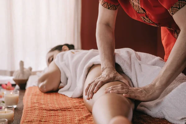 Vue recadrée du masseur faisant massage des pieds à la femme dans le salon de spa — Photo de stock