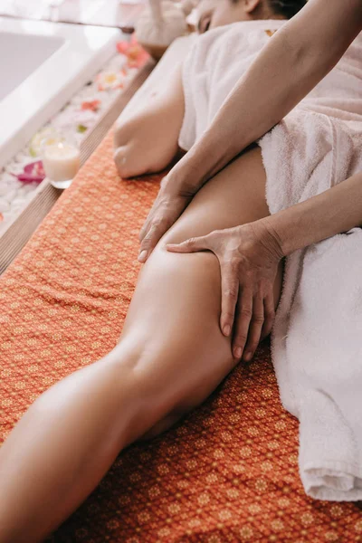 Vue recadrée du masseur faisant massage des pieds à la femme dans le salon de spa — Photo de stock