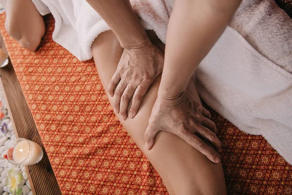 Vue recadrée du masseur faisant massage des pieds à la femme dans le salon de spa — Stock Photo