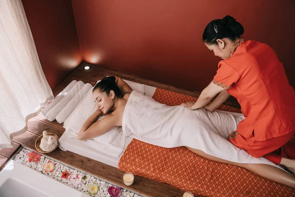 Vue grand angle de masseur faisant massage des pieds à la femme dans le salon de spa — Photo de stock