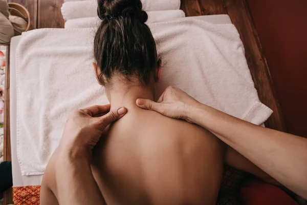 Cropped view of masseur doing neck massage to woman in spa salon — Stock Photo