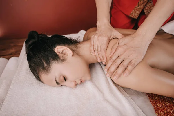 Vista cortada de massagista fazendo massagem no pescoço para a mulher no salão de spa — Fotografia de Stock