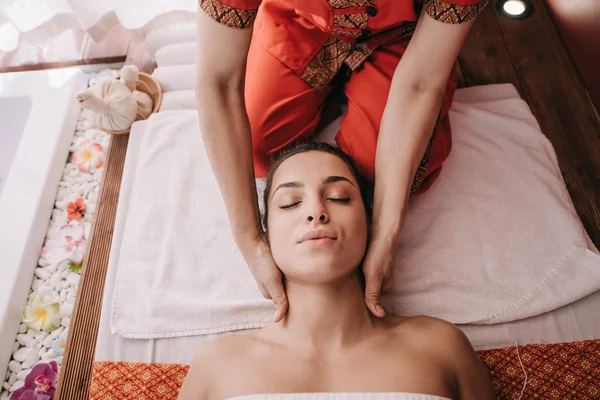 Recortado vista de masajista haciendo masaje de cuello a mujer en salón de spa - foto de stock