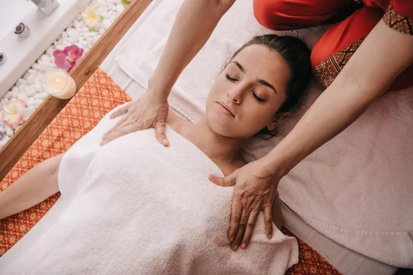 Обрезанный вид массажера, делающего массаж женщине в спа-салоне — стоковое фото