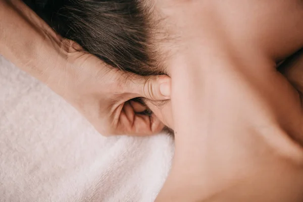 Vue recadrée du masseur faisant massage du cou à la femme dans le salon de spa — Photo de stock