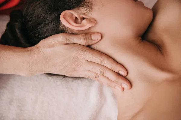 Vue recadrée du masseur faisant massage du cou à la femme dans le salon de spa — Photo de stock