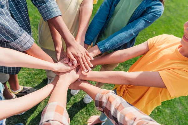 Cropped view of multiethnicl children putting hands together — Stock Photo