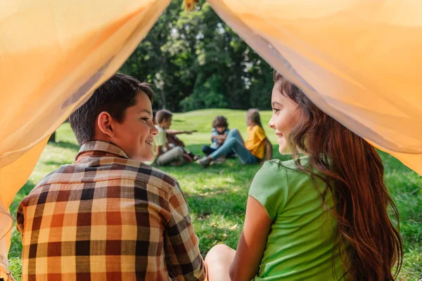 Selective focus of happy boy looking at cute friend in camp — Stock Photo