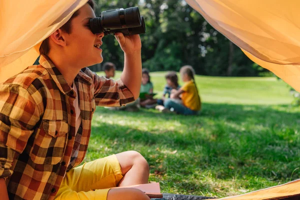 Fuoco selettivo di bambino felice che guarda attraverso binocolo — Foto stock