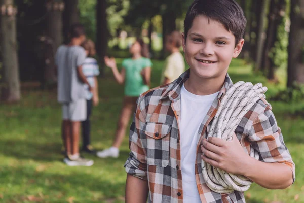 Селективное внимание счастливого мальчика, держащего верёвку в парке — стоковое фото