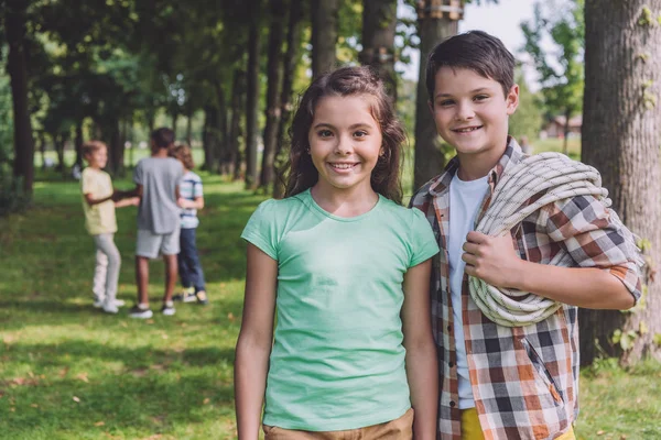 Selective focus of happy boy holding rope while standing with cute friend — Stock Photo