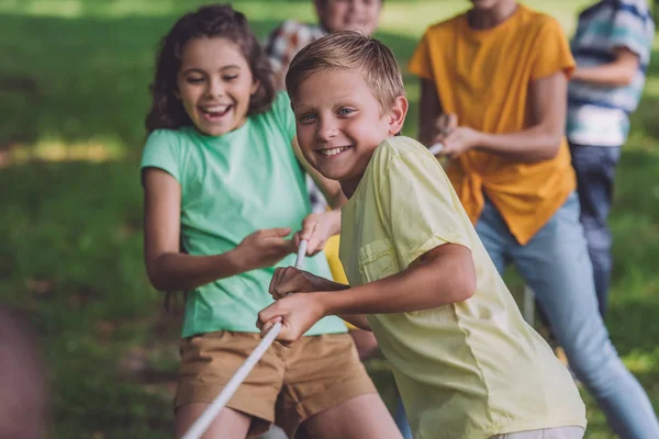 Focalizzazione selettiva di bambini felici che competono nel tiro alla fune — Foto stock