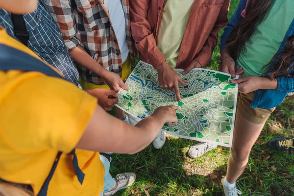 Cropped view of african american kid pointing with finger at map near friends — Stock Photo