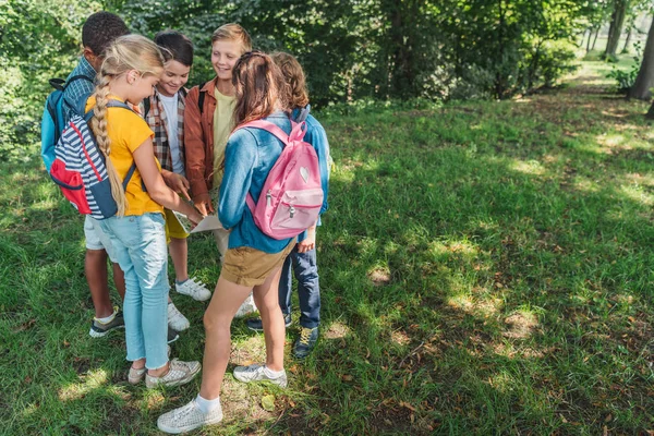 Happy multicultural kids standing near map outside — Stock Photo