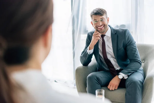 Enfoque selectivo de periodista hablando con hombre de negocios guapo en traje y gafas - foto de stock