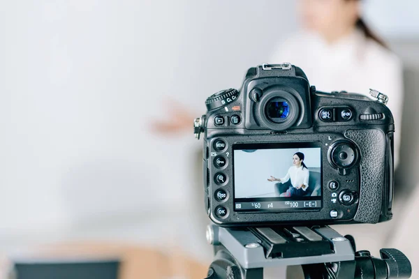 Selective focus of digital camera shooting journalist in office — Stock Photo