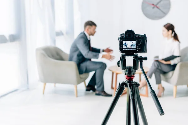 Selective focus of digital camera shooting journalist and businessman — Stock Photo