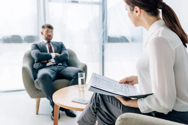 Selective focus of handsome businessman in suit and glasses talking with journalist — Stock Photo