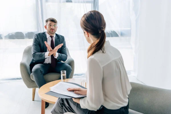 Selektiver Fokus eines gutaussehenden Geschäftsmannes in Anzug und Brille im Gespräch mit einem Journalisten — Stockfoto