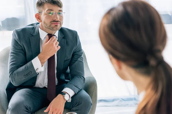 Focalizzazione selettiva di bell'uomo d'affari in giacca e cravatta e occhiali che parla con il giornalista — Foto stock