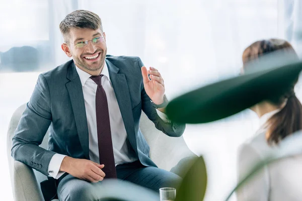 Focalizzazione selettiva di bell'uomo d'affari in giacca e cravatta e occhiali che parla con il giornalista — Foto stock