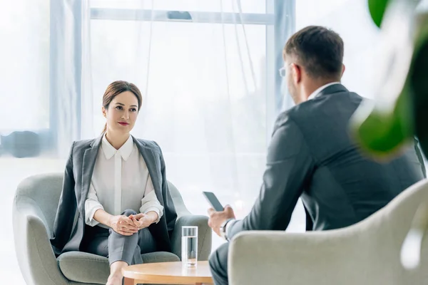 Selective focus of attractive journalist talking with businessman in suit — Stock Photo