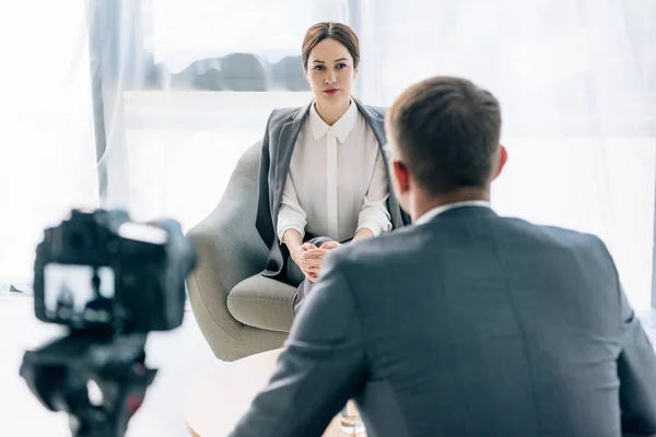 Selective focus of attractive journalist talking with businessman in suit — Stock Photo