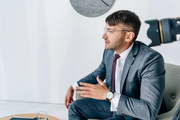 Вибірковий фокус красивого бізнесмена в формальному носінні розмовляє в офісі — стокове фото