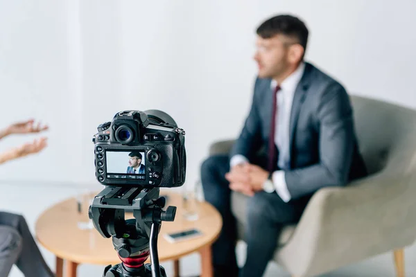 Selective focus of digital camera shooting businessman in formal wear — Stock Photo