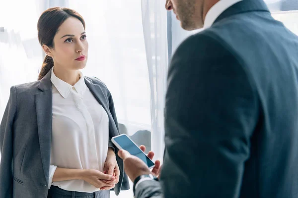 Selective focus of attractive journalist talking with businessman in formal wear — Stock Photo