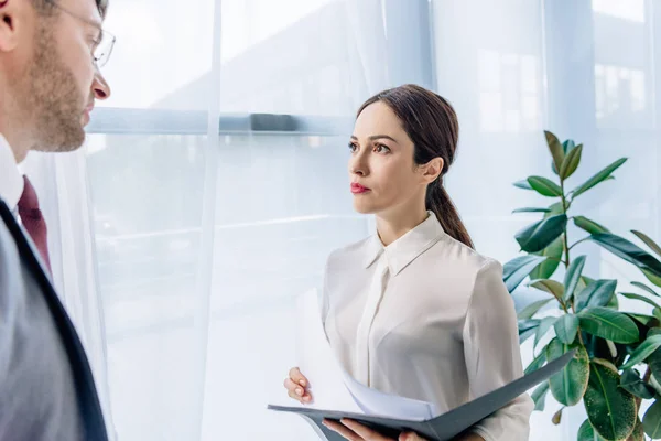 Selective focus of attractive journalist talking with businessman in office — Stock Photo