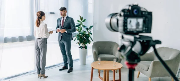 Panoramic shot of journalist talking with businessman in formal wear — Stock Photo