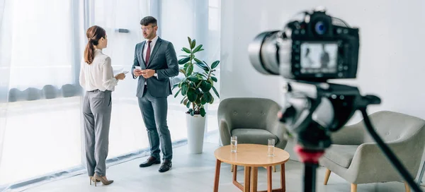 Plan panoramique de journaliste parlant avec un homme d'affaires en tenue de cérémonie — Photo de stock