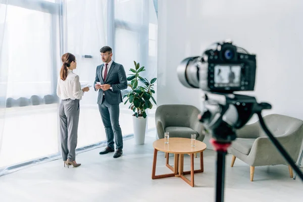 Selective focus of journalist talking with businessman in formal wear — Stock Photo