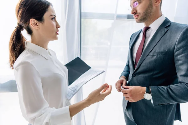 Vista lateral de periodista hablando con hombre de negocios en ropa formal - foto de stock