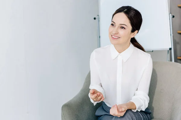 Attraktive Journalistin in offizieller Kleidung sitzt im Sessel im Büro — Stockfoto