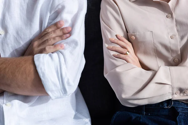 Частичный взгляд мужчины и женщины со скрещенными руками — стоковое фото