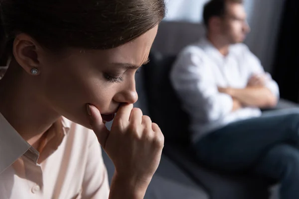 Upset pensive young woman and husband sitting on sofa — Stock Photo