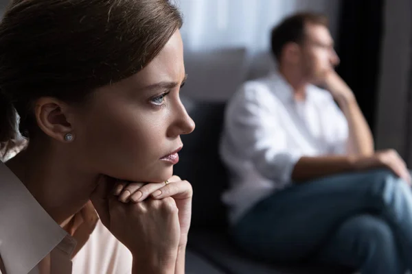 Расстроенные задумчивые молодая женщина и муж сидит на диване — стоковое фото