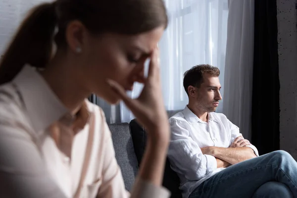 Селективное внимание грустной женщины и задумчивого мужчины на диване — стоковое фото
