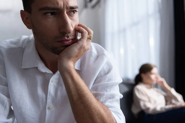 Cher triste homme avec anneau et femme sur canapé — Photo de stock